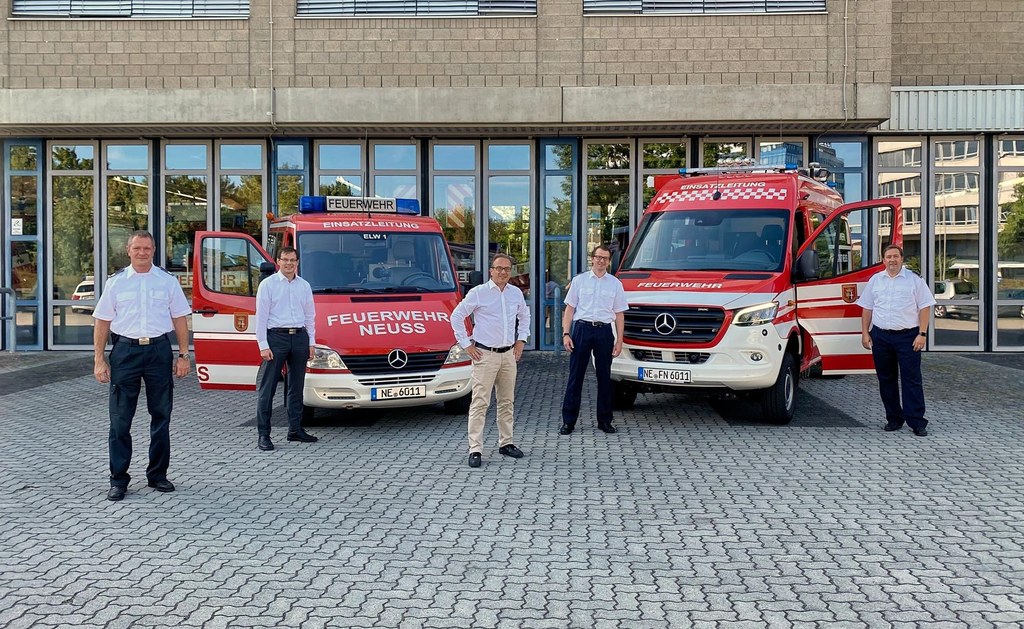 Thomas Brockers aus dem Sachgebiet Technik, Brandschutzdezernent Holger Lachmann, Bürgermeister Reiner Breuer, Amtsleiter der Feuerwehr Neuss Joachim Elblinger und der stellvertretende Amtsleiter Markus Brüggen vor den beiden Einsatzleitwagen (v.l.n.r.).