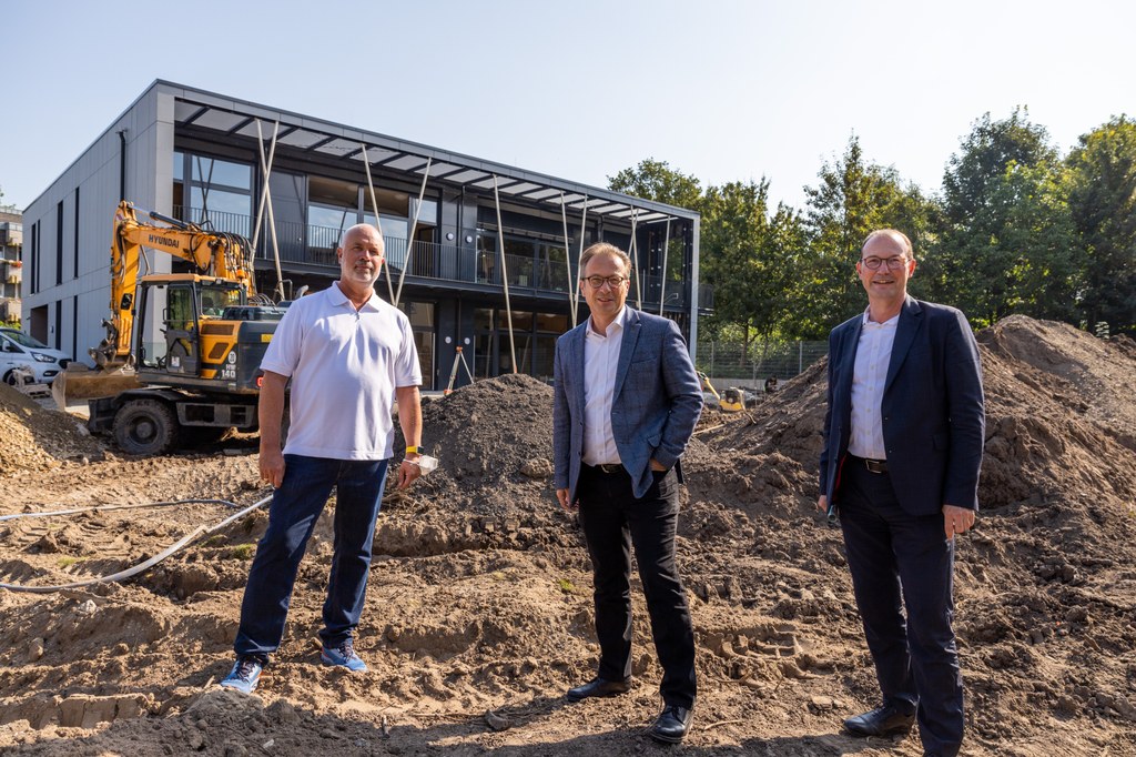 Foto: Stadt Neuss - (v.l.n.r.) Ralf Hörsken (Beigeordneter für Jugend, Integration und Soziales), Bürgermeister Reiner Breuer sowie Christoph Hölters (Beigeordneter für Planung, Bau und Verkehr) vor dem Kita-Neubau am Weißenberger Weg