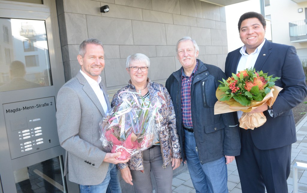 Aufsichtsratsvorsitzender Heinrich Thiel (r.) und Prokurist Niki Lüdtke (l.) übergeben an die Eheleute Siepe Blumen zum Einzug.