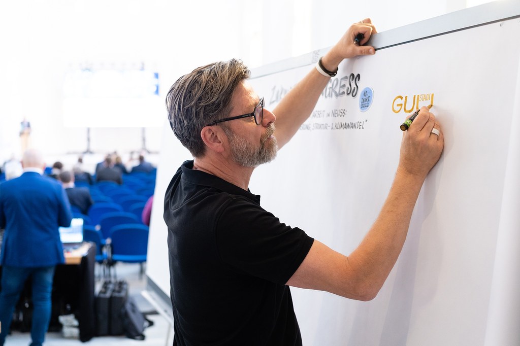 Christoph Illigens zeichnet an ein Whiteboard.