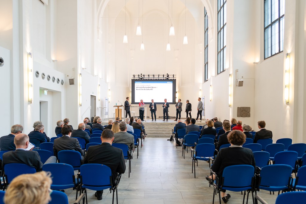 Die Panelteilnehmer stehen auf der Bühne des Zeughauses und diskutieren.